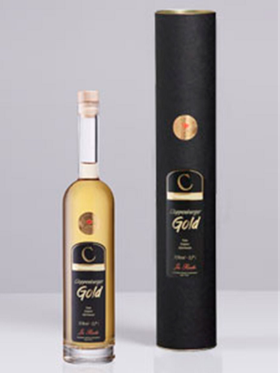 Flasche Cloppenburger Gold Likör mit schwarzer Geschenkverpackung auf grauem Hintergrund